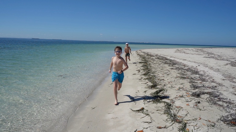 Niños corriendo por la playa de Cayo Blanco
