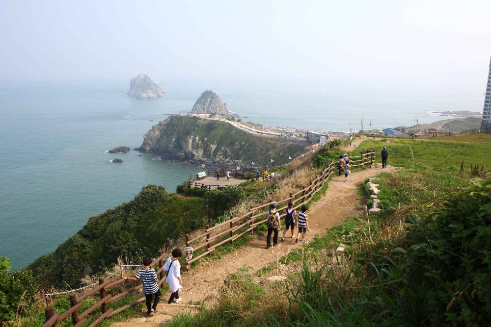 Senderistas recorren el litoral de Busan con vistas a los islotes de Oryukdo. Senderistas recorren el litoral de Busan con vistas a los islotes de Oryukdo.