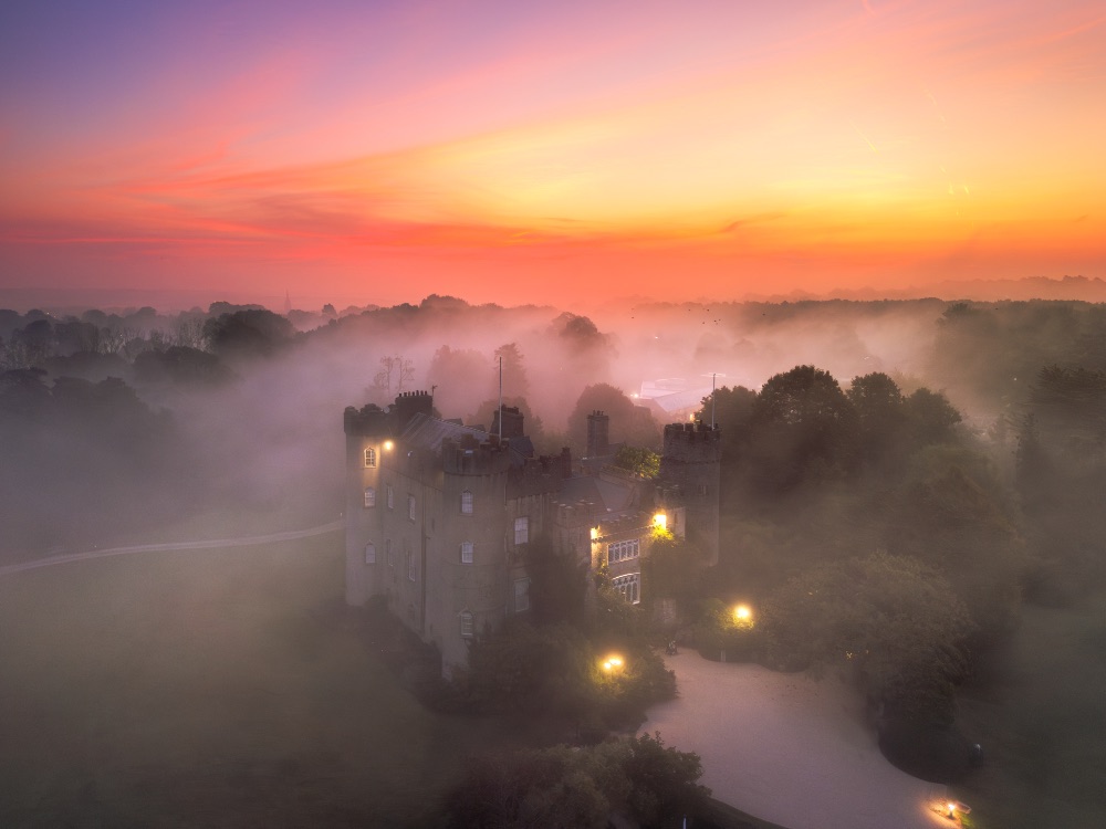 El castillo de Malahide, en el condado de Dublín, emerge entre la niebla bajo las primeras luces del día. El castillo de Malahide, en el condado de Dublín, emerge entre la niebla bajo las primeras luces del día.